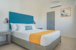 1 dormitorio con 1 cama grande y cabecero azul en Hotel Roca Sunzal en La Libertad