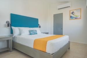 a bedroom with a large bed with a blue headboard at Hotel Roca Sunzal in La Libertad