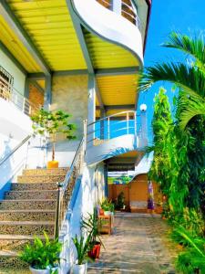 a building with stairs and plants in front of it at Emshienell Beach Resort and Event Place in Zambales