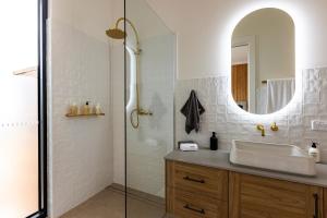 a bathroom with a sink and a shower with a mirror at Benbullen Retreat in Angaston