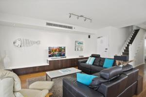 a living room with a couch and a table at Beachfront Dream - Direct Beachfront in Narrabeen