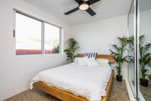 una camera con letto e ventilatore a soffitto di Yulunga - Direct Beachfront a Narrabeen