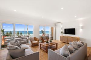 a living room with a view of the ocean at Sweeping Panoramic Views - Brand New Beach House in Curl Curl