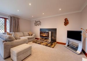 a living room with a couch and a fire place at Nursery Cottage in Clippesby