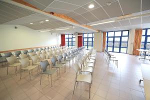 Großes Zimmer mit Stühlen, Tischen und Fenstern in der Unterkunft Auberge La Digue in Calais