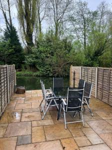 a patio with a table and chairs and a pond at Rickmansworth Lodge in Watford