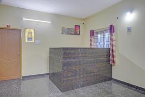 Pokój z drewnianą ścianą i drzwiami w obiekcie Vsv Guest House w mieście Ćennaj