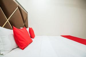 a bedroom with a bed with red pillows on it at Hotel Sunrise in Ludhiana