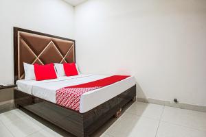 a bedroom with a bed with red pillows on it at Hotel Sunrise in Ludhiana
