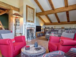 a living room with red chairs and a fireplace at 5 bedroom luxury Chalet by Dieckereise in Verbier