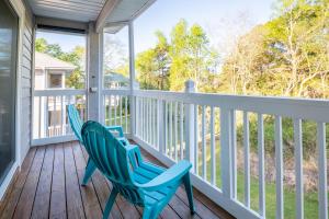 two blue chairs sitting on the front porch of a house at Condo in St James in Southport - Great amenities in Southport +34 photos