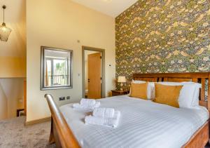 a bedroom with a large bed with towels on it at The Apple Tree - Pershore in Pershore