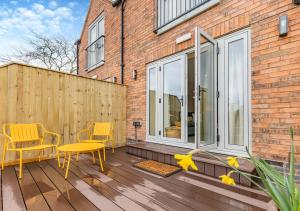 a patio with two chairs and a yellow table at The Apple Tree - Pershore in Pershore
