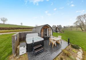 a tiny house on a deck with a bed and a table at Paradwys in Llanfyllin