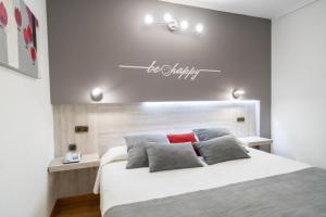 a bedroom with a bed and a sign that reads be unhappy at Hotel Mozárbez Salamanca in Mozárbez