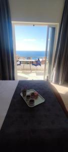 a tray of food on a bed with a view of the ocean at Ionian View in Gjilek