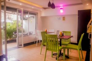 comedor con mesa y sillas verdes en Dayo Suites & Hotel en Nairobi