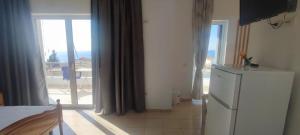 a kitchen with a refrigerator and a view of the ocean at Ionian View in Gjilek