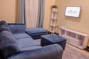uma sala de estar com um sofá e uma cadeira em Dayo Suites & Hotel em Nairobi