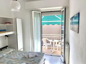 een slaapkamer met een bed en een balkon met een tafel bij Hotel Villa Chiara in Finale Ligure
