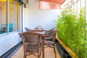 uma mesa e cadeiras numa varanda com plantas em Dayo Suites and Hotel em Nairobi