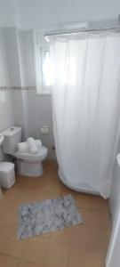 a bathroom with a toilet and a white shower curtain at Ionian View in Gjilek
