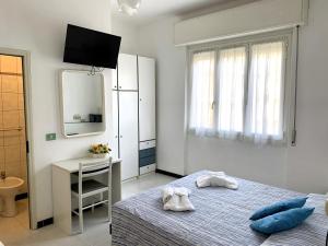 een witte slaapkamer met een bed en een spiegel bij Hotel Villa Chiara in Finale Ligure