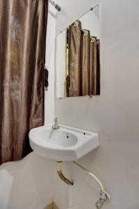 lavabo blanco en el baño con espejo en The Greenpark Retreat, Mahabaleshwar, en Mahabaleshwar