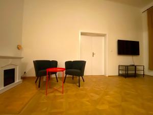 una stanza con due sedie e un tavolo rosso di Katerina's Downtown Apartments a Praga
