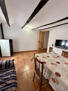 ein Wohnzimmer mit einem Tisch und einem TV in der Unterkunft Casa puebla de Arenoso II Rental Holidays REF.066 in Puebla de Arenoso
