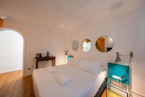 a bedroom with a white bed and two mirrors at Giardini Penelope Resort e Spa in Ciampino +118 photos