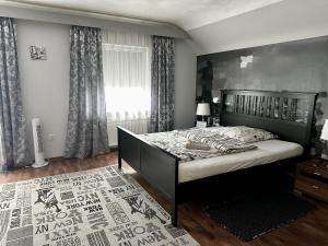 1 dormitorio con 1 cama y una ventana con cortinas en Haus Alt - Ferienwohnung, en Illingen