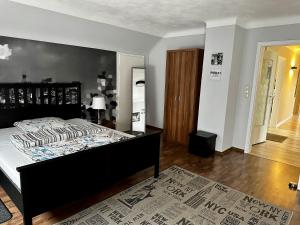 1 dormitorio con 1 cama con cabecero negro en Haus Alt - Ferienwohnung, en Illingen