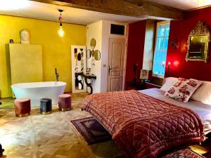 ein Schlafzimmer mit einer Badewanne, einem Bett und einer Badewanne in der Unterkunft Manoir de La Barre Ceton in Ceton