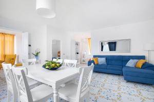 a living room with a white table and a blue couch at Villa Il Canto delle Sirene in Marciano