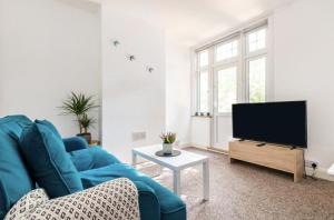 a living room with a blue couch and a tv at Beautiful 1-Bed Apartment with Garden in London in London