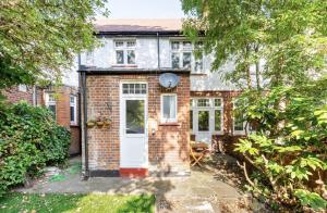 an old brick house with a white door at Beautiful 1-Bed Apartment with Garden in London in London