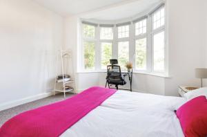 een slaapkamer met een groot bed met een roze deken erop bij Beautiful 1-Bed Apartment with Garden in London in Londen