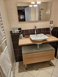 een badkamer met een wastafel en een spiegel bij Hotel du Saumon, Verneuil sur Avre in Verneuil d’Avre et d’Iton