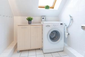 een wasruimte met een wasmachine en droger bij Wohnpark Heisterbusch Ferienhaus 13d in Kellenhusen