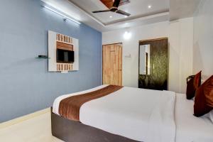 a bedroom with a large bed and a tv at The Greenpark Retreat, Mahabaleshwar in Mahabaleshwar