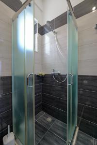 a shower with a glass door in a bathroom at Valentina Apartment 1 in Sarandë