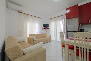 a living room with two couches and a kitchen at Valentina Apartment 1 in Sarandë