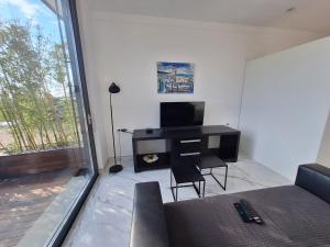 un soggiorno con TV, tavolo e sedie di Apartment Solis a Portoroz