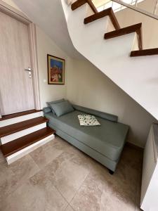 Habitación pequeña con cama bajo una escalera en Estia guest house en Olympia