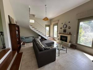 Estia guest house في أوليمبيا: غرفة معيشة مع أريكة ومدفأة