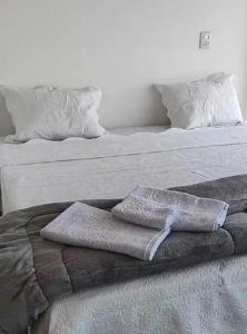 Dos camas con toallas encima. en Chale Vista Encantada, en Lavras Novas