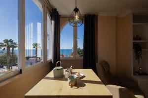 uma sala de jantar com uma mesa e uma grande janela em Nordik Apartments Urban - Playa Virginia "Hanko" em Málaga