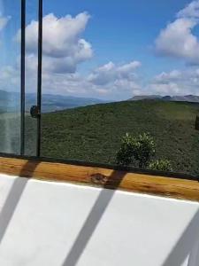 a window with a view of a field of grass at Chale Vista Encantada in Lavras Novas