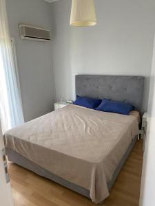um quarto com uma cama grande e almofadas azuis em Johnny house em Atenas